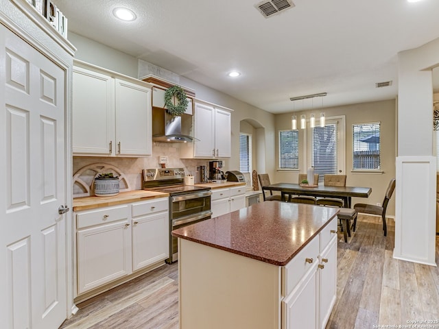 1215 Cresswell Cv, San Antonio, TX 78258 - kitchen featuring double oven range, arched walkways, light wood-style floors, backsplash, and recessed lighting
