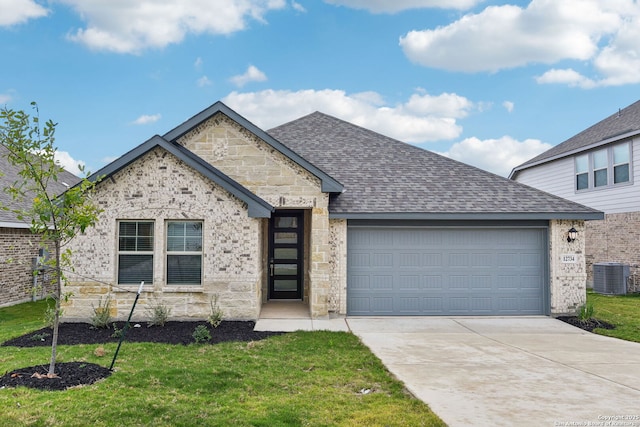 12734 Tegea Pass, San Antonio, TX 78245 - view of front of home featuring central AC, a garage, driveway, a front lawn, and stone siding