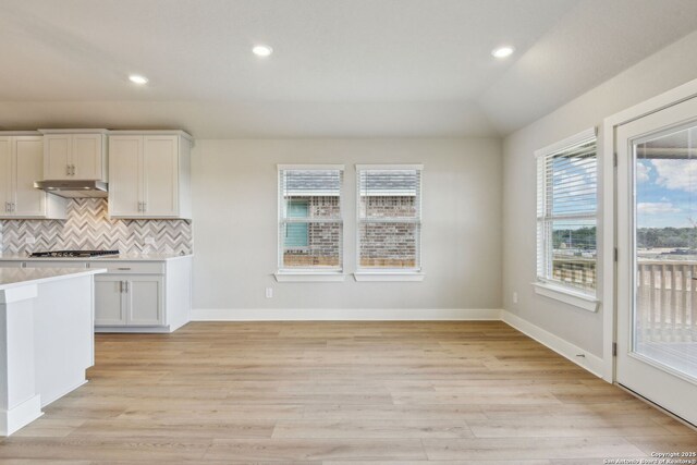 12734 Tegea Pass, San Antonio, TX 78245 - kitchen with light countertops, backsplash, under cabinet range hood, light wood-style flooring, and recessed lighting
