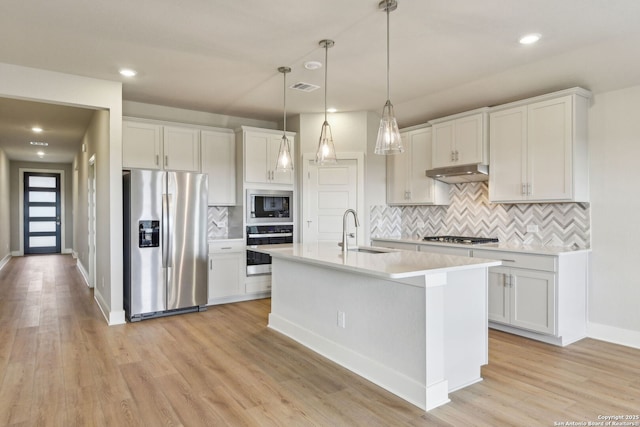 12734 Tegea Pass, San Antonio, TX 78245 - kitchen featuring appliances with stainless steel finishes, a sink, under cabinet range hood, decorative backsplash, and light countertops