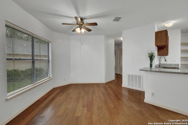 3807 Pine Breeze, San Antonio, TX 78247 - unfurnished living room featuring a sink, a ceiling fan, wood finished floors, and baseboards