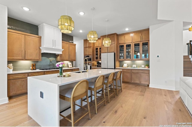 4003 Wood Crk, San Antonio, TX 78257 - kitchen with freestanding refrigerator, decorative backsplash, brown cabinetry, light wood-style floors, and recessed lighting