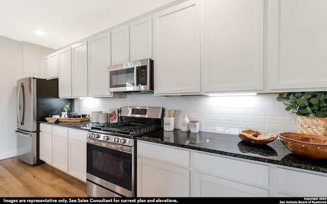 189 Kayla Ave, San Antonio, TX 78253 - kitchen featuring stainless steel appliances, white cabinetry, light wood-style flooring, and dark stone countertops