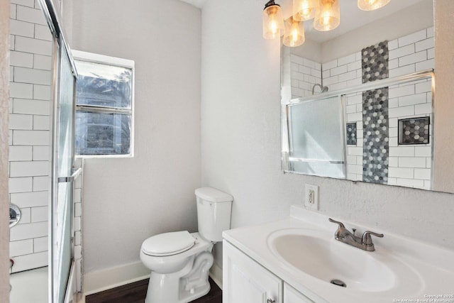 140 E Dullnig, San Antonio, TX 78223 - bathroom featuring a shower with shower door, toilet, vanity, baseboards, and wood finished floors