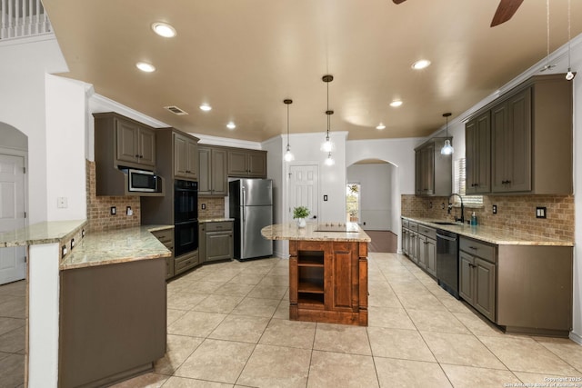 2611 Caravan Cir, San Antonio, TX 78258 - kitchen with appliances with stainless steel finishes, arched walkways, a sink, a peninsula, and ornamental molding