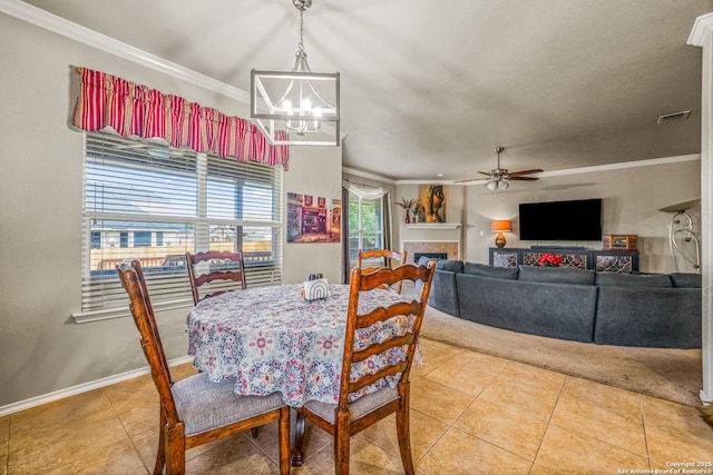 222 Red Quill Nest, San Antonio, TX 78253 - dining area featuring light tile patterned flooring, crown molding, a chandelier, a ceiling fan, and a fireplace