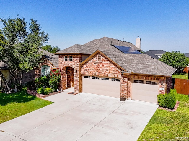222 Red Quill Nest, San Antonio, TX 78253 - view of front of home with an attached garage, concrete driveway, roof mounted solar panels, brick siding, and a shingled roof