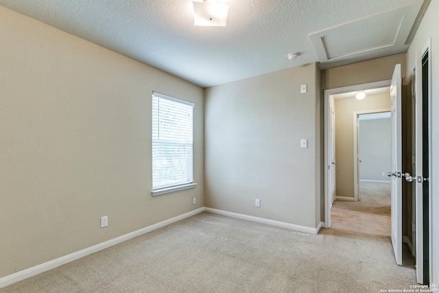 6046 Luckey Run, San Antonio, TX 78252 - spare room with light colored carpet, attic access, a smoke detector, baseboards, and a textured ceiling