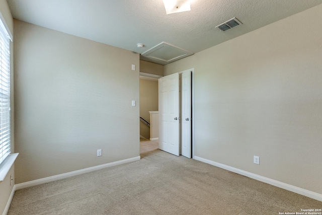 6046 Luckey Run, San Antonio, TX 78252 - carpeted empty room featuring plenty of natural light, baseboards, attic access, and a textured ceiling
