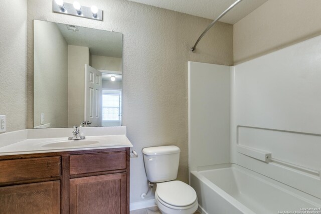 6046 Luckey Run, San Antonio, TX 78252 - full bath with toilet, vanity, a textured wall, and bathing tub / shower combination
