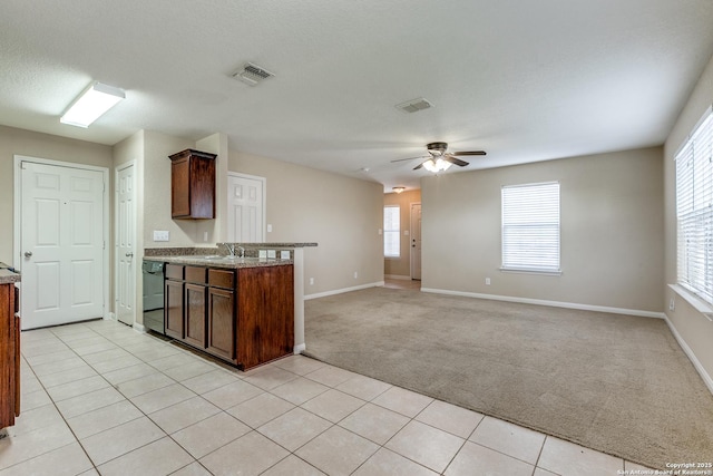 6046 Luckey Run, San Antonio, TX 78252 - kitchen with light colored carpet, ceiling fan, baseboards, and light stone countertops