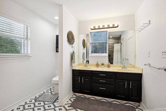 full bath with baseboards, double vanity, toilet, and a shower with curtain
