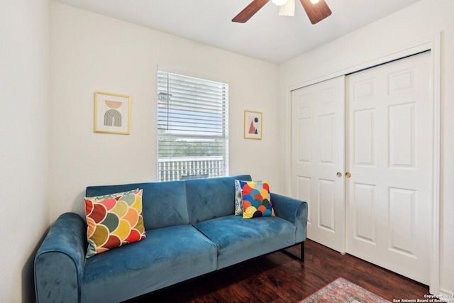 living room featuring a ceiling fan and dark wood-style floors
