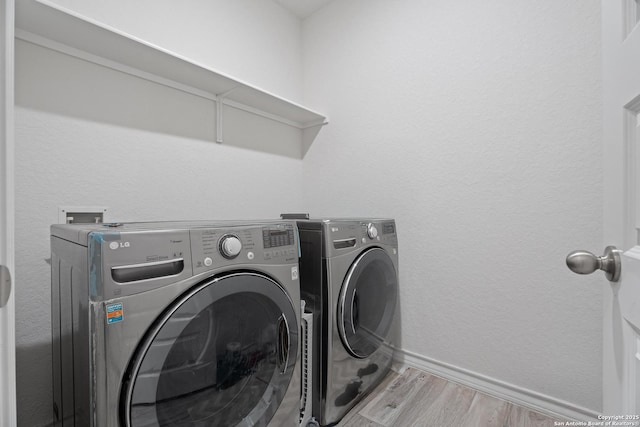 10836 Bango Farms, San Antonio, TX 78254 - laundry area with washer and clothes dryer, wood finished floors, and baseboards