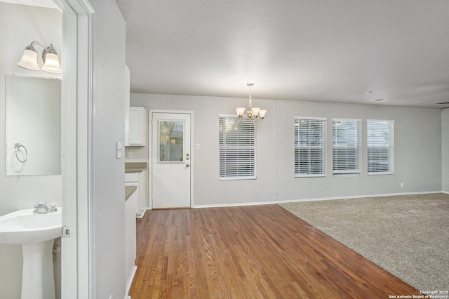 135 Blue Juniper, San Antonio, TX 78253 - unfurnished dining area with a chandelier, a sink, baseboards, and wood finished floors