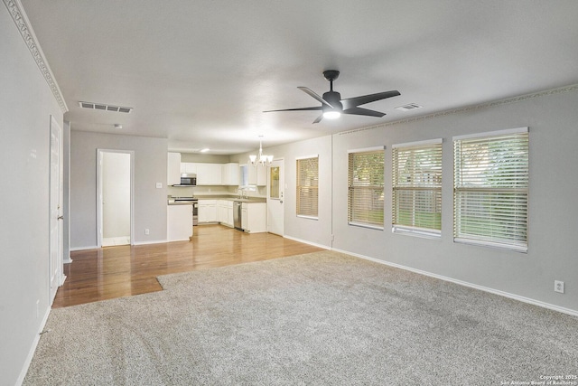 135 Blue Juniper, San Antonio, TX 78253 - unfurnished living room featuring light carpet, a chandelier, a ceiling fan, and baseboards