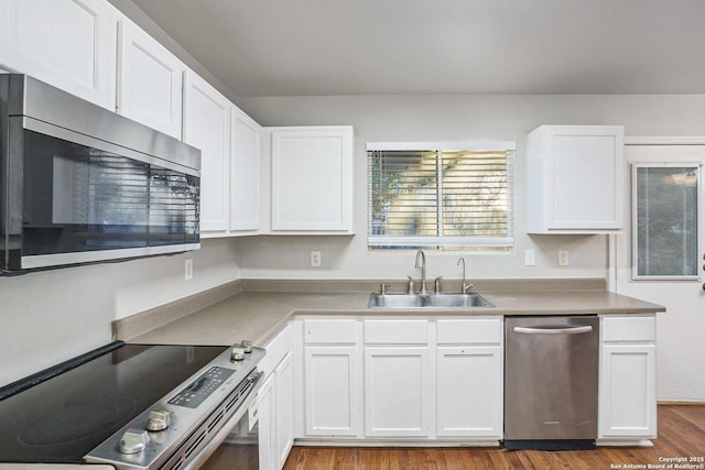 135 Blue Juniper, San Antonio, TX 78253 - kitchen featuring appliances with stainless steel finishes, a sink, white cabinets, wood finished floors, and light countertops