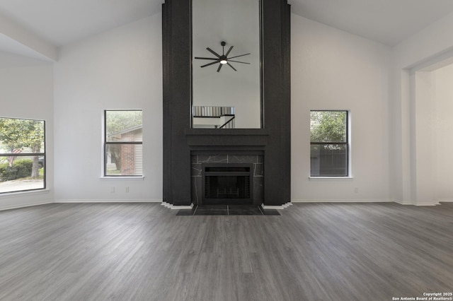 16726 Burning Glade, San Antonio, TX 78247 - unfurnished living room with wood finished floors, baseboards, a fireplace, high vaulted ceiling, and healthy amount of natural light