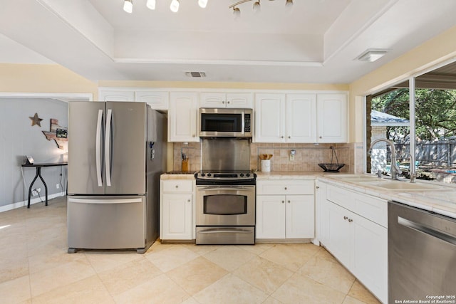 13018 Country Trl, San Antonio, TX 78216 - kitchen featuring stainless steel appliances, a sink, a raised ceiling, and tasteful backsplash