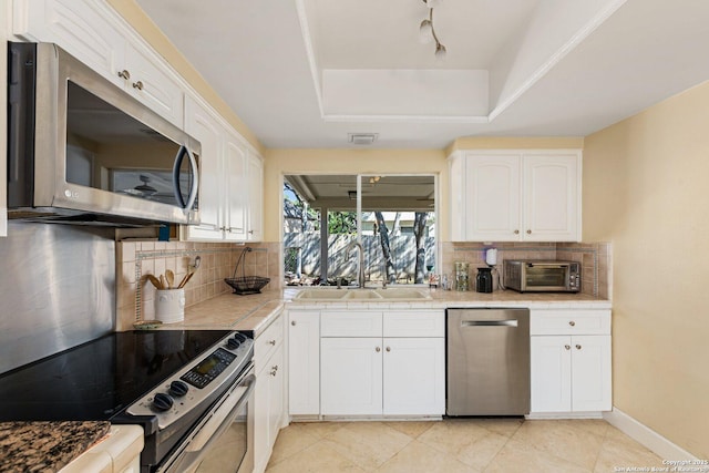 13018 Country Trl, San Antonio, TX 78216 - kitchen featuring stainless steel appliances, tile countertops, a sink, and decorative backsplash