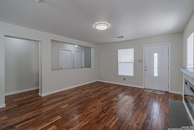 10202 Misty Pln, San Antonio, TX 78245 - foyer entrance with dark wood-style flooring, baseboards, and a glass covered fireplace