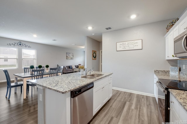 14383 Palm Rdg, San Antonio, TX 78253 - kitchen featuring stainless steel appliances, a sink, wood finished floors, a kitchen island with sink, and recessed lighting