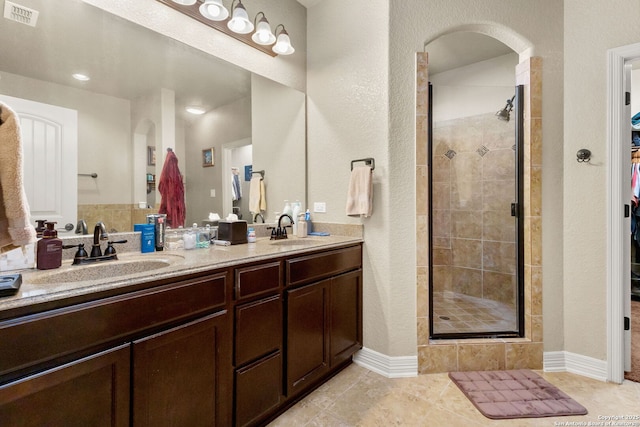 13706 Trailside, Live Oak, TX 78233 - bathroom featuring a shower stall, double vanity, tile patterned floors, and a textured wall
