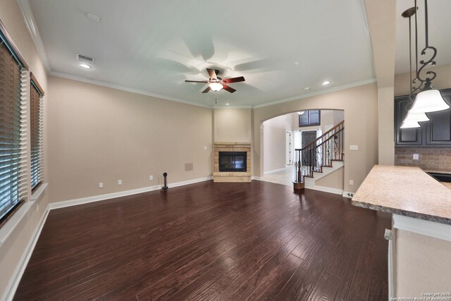 523 White Cyn, San Antonio, TX 78260 - unfurnished living room with a glass covered fireplace, a ceiling fan, arched walkways, recessed lighting, and stairway