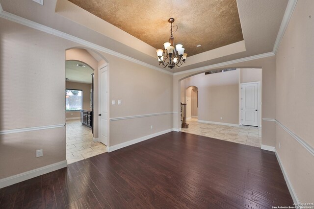 523 White Cyn, San Antonio, TX 78260 - spare room featuring arched walkways, a raised ceiling, hardwood / wood-style floors, a chandelier, and baseboards