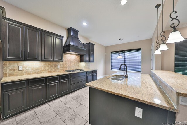 523 White Cyn, San Antonio, TX 78260 - kitchen featuring custom exhaust hood, stainless steel gas stovetop, tasteful backsplash, an island with sink, and a sink