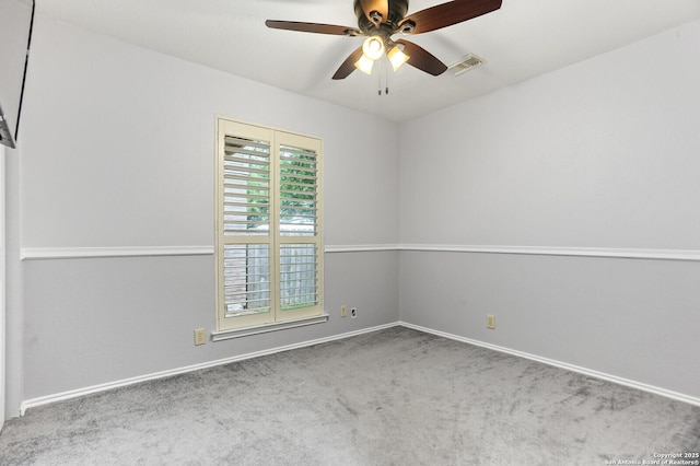carpeted empty room featuring ceiling fan and baseboards