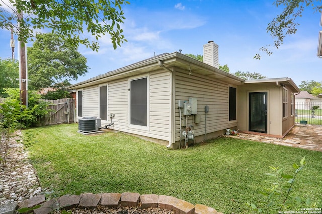 rear view of property with a chimney, central AC, and a patio