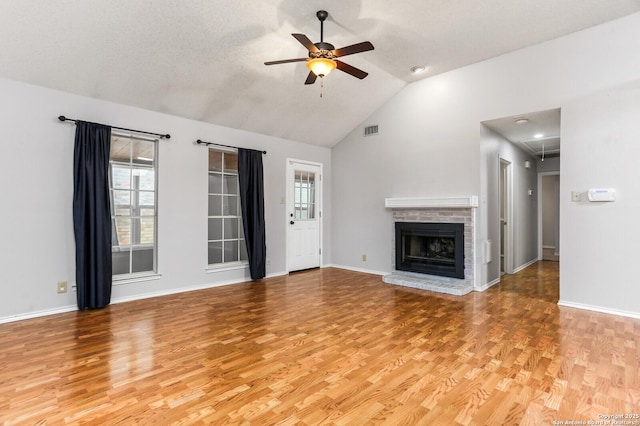 unfurnished living room featuring a ceiling fan, light wood-style flooring, healthy amount of natural light, and high vaulted ceiling