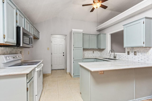 kitchen featuring white range with electric cooktop, a sink, a peninsula, stainless steel microwave, and lofted ceiling