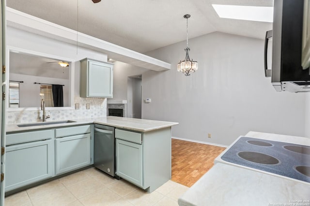 kitchen with a sink, stainless steel appliances, a skylight, a ceiling fan, and lofted ceiling