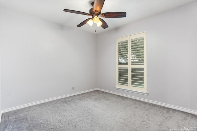carpeted spare room featuring a ceiling fan and baseboards