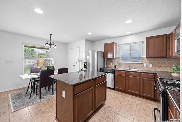 102 Ville Serene, San Antonio, TX 78253 - kitchen featuring appliances with stainless steel finishes, a sink, a chandelier, decorative backsplash, and a center island