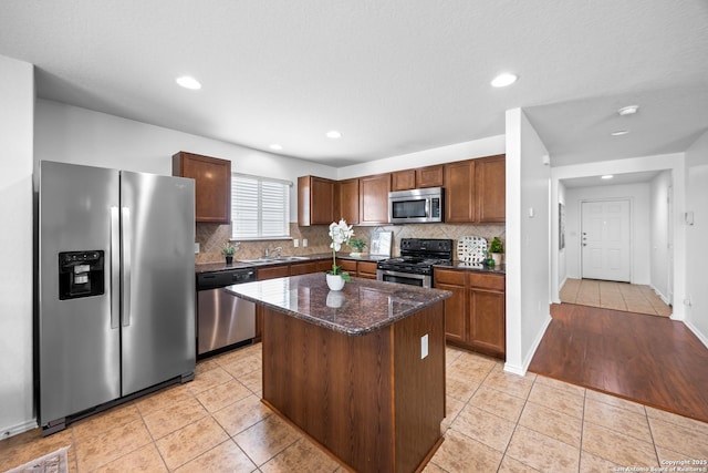 102 Ville Serene, San Antonio, TX 78253 - kitchen with stainless steel appliances, a sink, backsplash, light tile patterned floors, and dark stone countertops