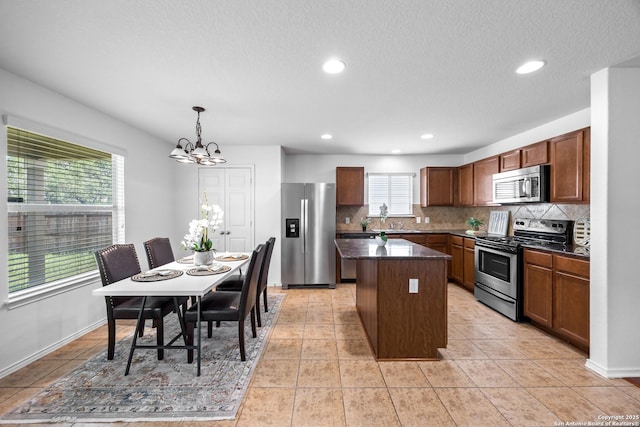 102 Ville Serene, San Antonio, TX 78253 - kitchen with appliances with stainless steel finishes, a chandelier, backsplash, a kitchen island, and a sink