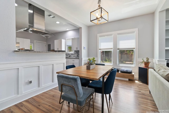 944 Fulton, San Antonio, TX 78201 - dining area featuring a decorative wall, a chandelier, light wood-style floors, wainscoting, and recessed lighting