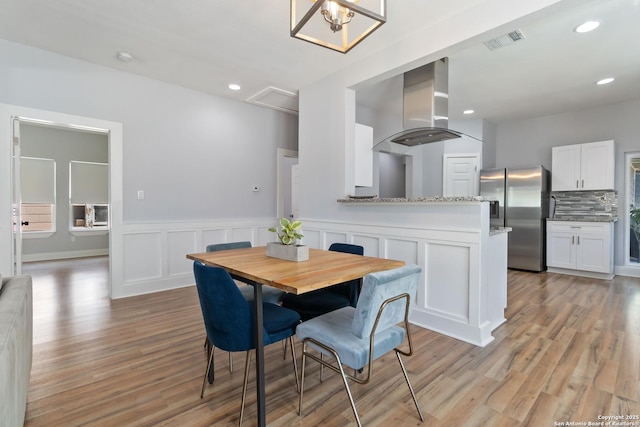 944 Fulton, San Antonio, TX 78201 - dining space featuring light wood-style floors, wainscoting, recessed lighting, and a decorative wall