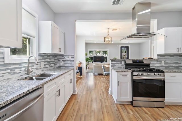 944 Fulton, San Antonio, TX 78201 - kitchen featuring stainless steel appliances, a sink, island exhaust hood, white cabinets, and backsplash