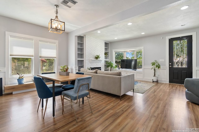 944 Fulton, San Antonio, TX 78201 - dining space featuring wood finished floors, recessed lighting, a brick fireplace, a chandelier, and built in features