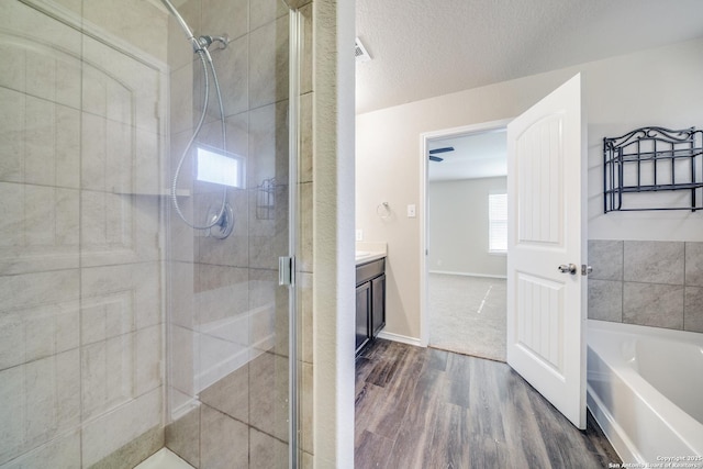 12358 Erstein, Selma, TX 78154 - bathroom with a shower stall, wood finished floors, vanity, a garden tub, and a textured ceiling