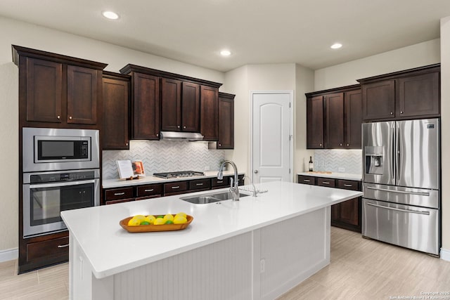 28114 Versant, Boerne, TX 78015 - kitchen with appliances with stainless steel finishes, dark brown cabinets, light countertops, an island with sink, and recessed lighting