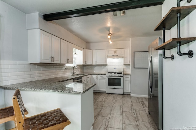 4439 Tropical Dr, San Antonio, TX 78218 - kitchen with white range with gas cooktop, under cabinet range hood, a peninsula, a sink, and decorative backsplash