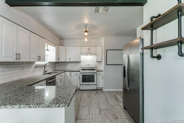 4439 Tropical Dr, San Antonio, TX 78218 - kitchen featuring appliances with stainless steel finishes, a sink, under cabinet range hood, decorative backsplash, and white cabinets
