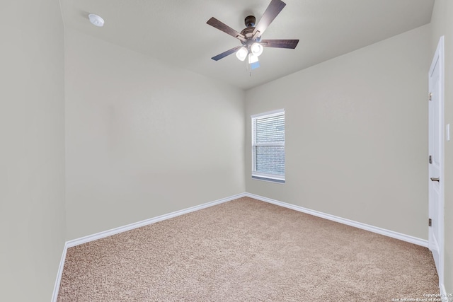 empty room with carpet, baseboards, ceiling fan, and a smoke detector