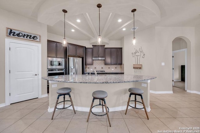 kitchen featuring stainless steel appliances, recessed lighting, dark brown cabinets, light tile patterned floors, and a kitchen bar