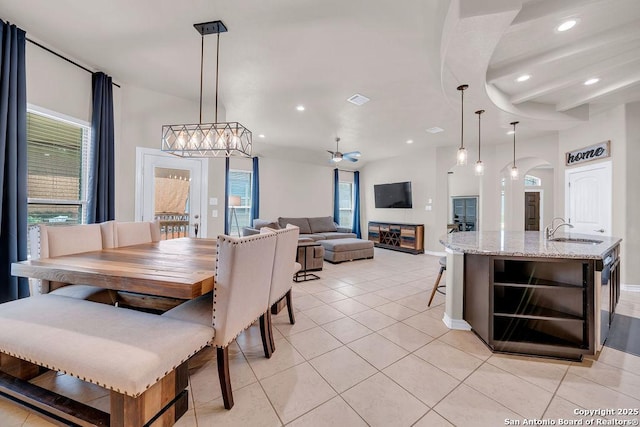 dining room featuring plenty of natural light, light tile patterned flooring, arched walkways, recessed lighting, and baseboards